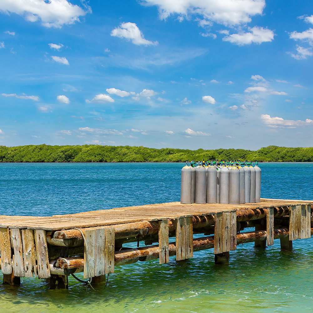 Group of oxygen tanks stands on jetty in sea